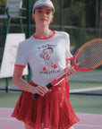 Person wearing a Betty Boop-themed shirt and visor on a tennis court