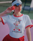 Person wearing a Betty Boop-themed shirt and visor on a tennis court