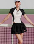Woman in a black and white outfit with a logo on a tennis court