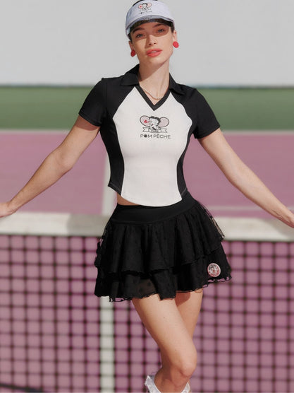 Woman in a black and white outfit with a logo on a tennis court