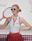 Woman in vintage tennis outfit holding a racket on a tennis court