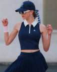Close-up of navy blue tennis skirt fabric – knife pleats and asymmetrical hem detail.