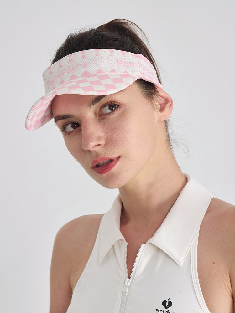 Pink checkered tennis visor with Pom Pêche logo and adjustable strap.