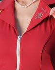 Red jacket with a rose emblem and pearl necklace
