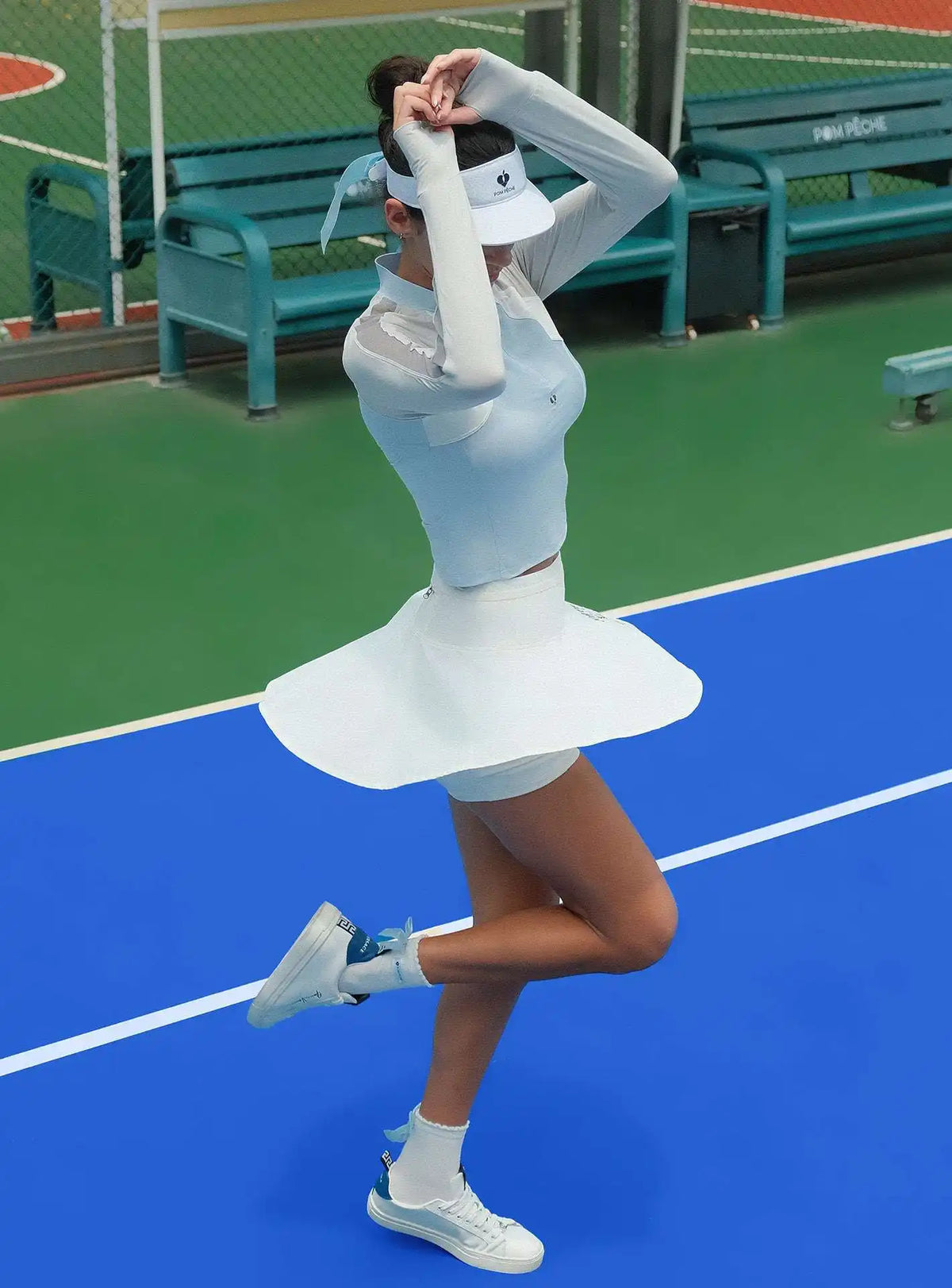 Tennis player in a white outfit on a tennis court