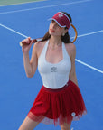 Model posing in wine red tulle puff tennis skirt with racquet, showing soft layered mesh and a high-waisted athletic tennis skirt fit.