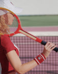 Person holding a red tennis racket on a tennis court