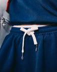 Close-up of navy tennis skirt waistband with white drawstring and custom tennis racket pendants.