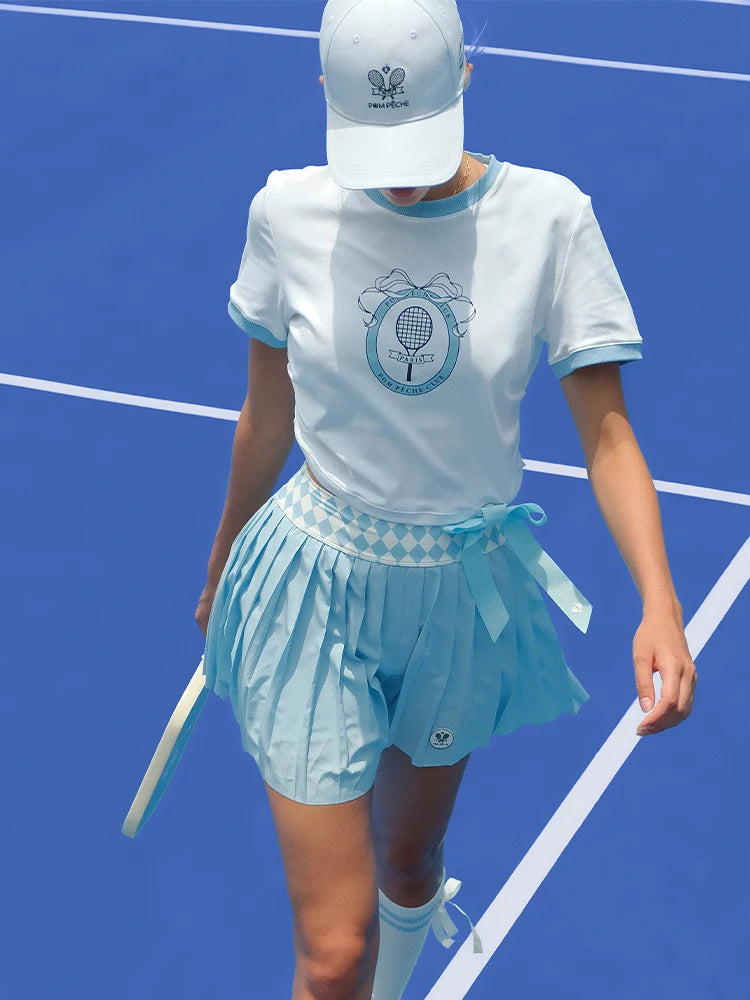 Person wearing a blue and white tennis outfit on a blue tennis court