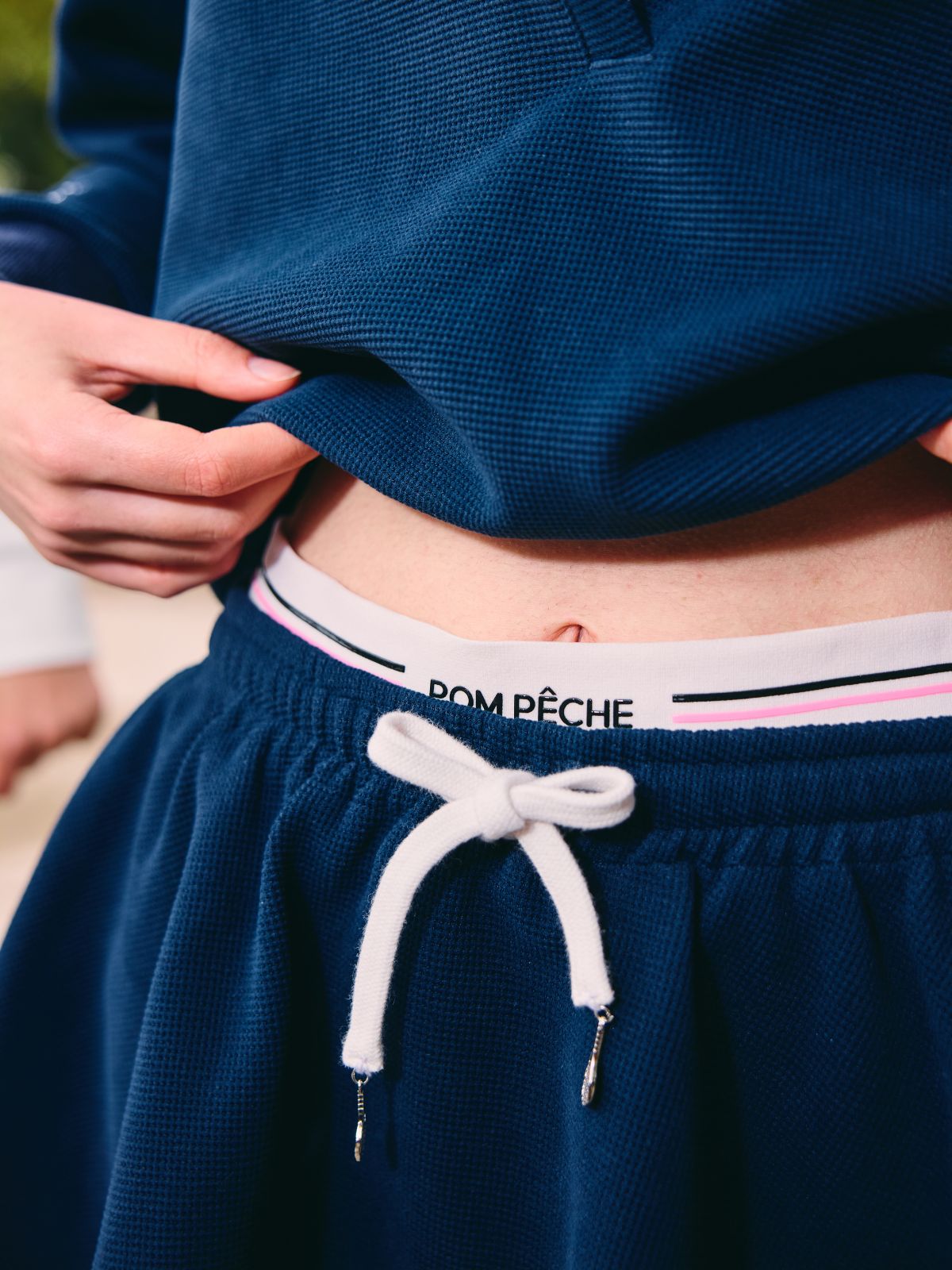 Navy blue athletic shorts with a white drawstring and brand logo