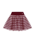 A flat lay of a red argyle mesh tennis skirt featuring a lightweight pleated mesh overlay and wide waistband, shown against a clean white background