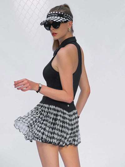Woman wearing a black sleeveless top and houndstooth patterned skirt on a white background