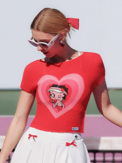 Person wearing a red shirt with a heart design and white sunglasses, standing outdoors.