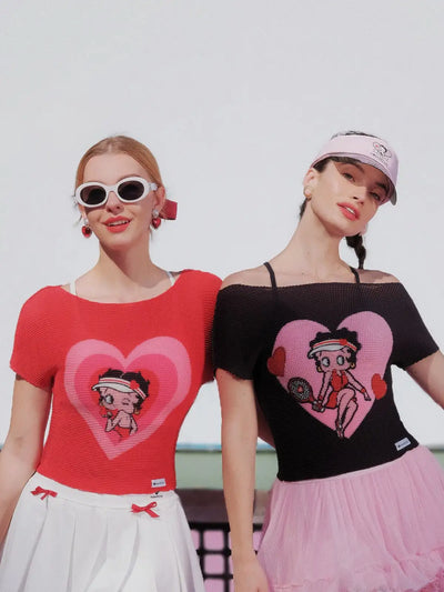 Two women wearing t-shirts with cartoon character designs on a white background
