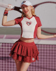Woman in red and white tennis outfit on a tennis court
