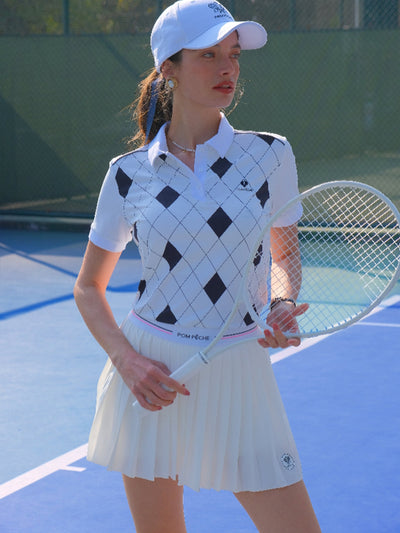 White and black checkered polo top with diamond pattern and subtle logo, styled on the tennis court.