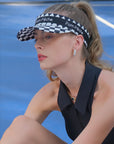 Black checkered tennis visor with Pom Pêche logo and adjustable strap.