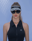 Black checkered tennis visor with Pom Pêche logo and adjustable strap.