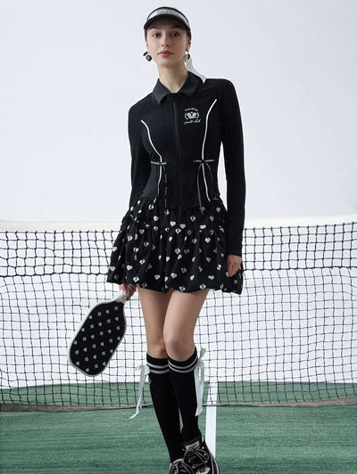 Black sun-protective tennis jacket with a sculpted fit, adjustable waist ties, and dual ball pockets.