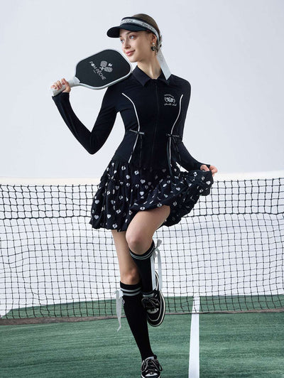 Black sun-protective tennis jacket with a sculpted fit, adjustable waist ties, and dual ball pockets.