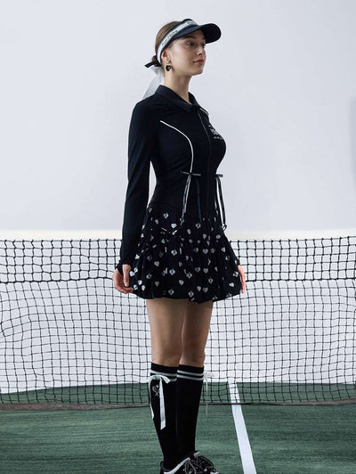 Black sun-protective tennis jacket with a sculpted fit, adjustable waist ties, and dual ball pockets.