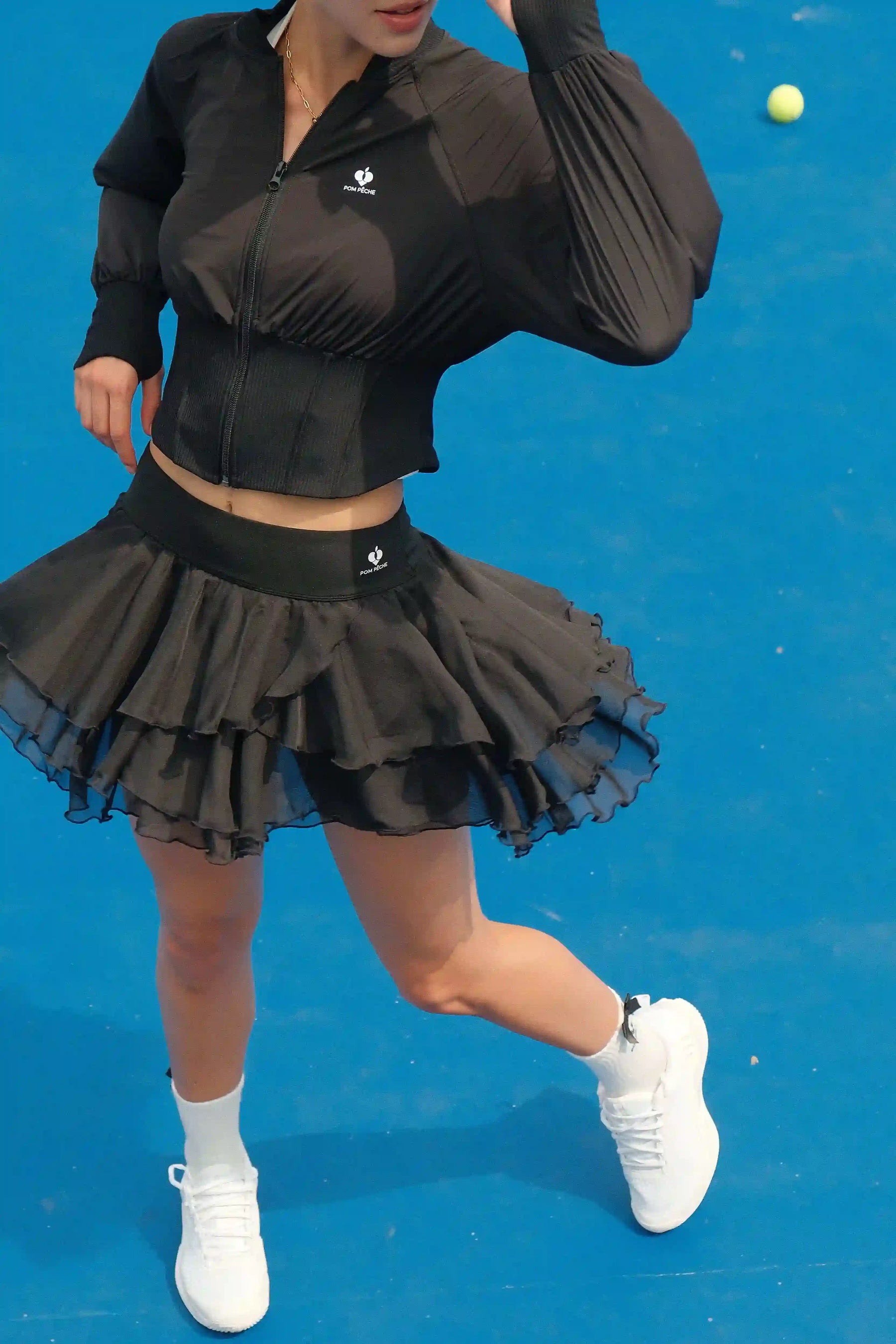 Person wearing a black outfit with a skirt on a blue background