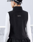 Warm black fleece vest with high-neck zip design and embroidered chest pocket, styled on the tennis court.