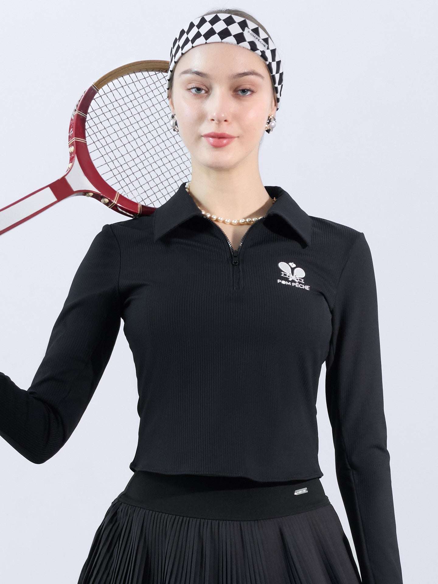 Black long-sleeve zip-collar polo top with a subtle printed logo, featuring a fitted silhouette for a sleek, sporty look.