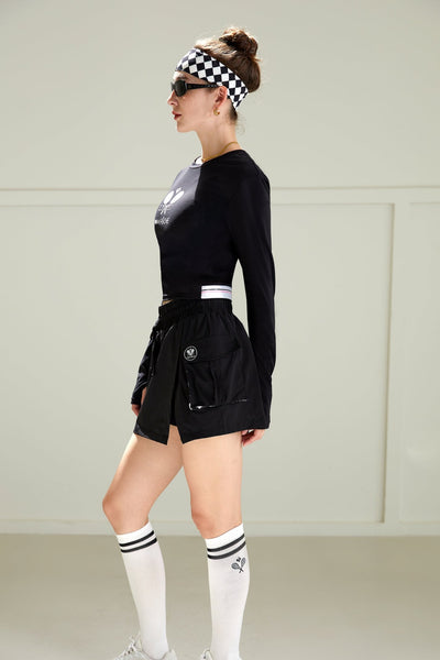 Black cropped long-sleeve tee with a round neckline, featuring printed logo in the center. 