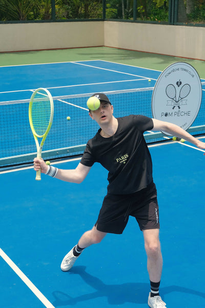 Black sports tee with a 'Paris' graphic and brand logo, designed for comfort and style during activities.