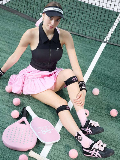 Tennis look featuring a black patella support strap with bow print. 