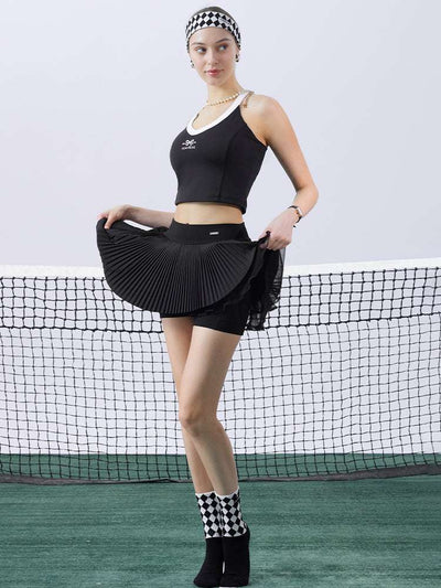 Black pleated tennis skirt with flared pleats and mesh layers during tennis movement