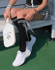 Black knee-high tennis socks with classical white stripes, bow detail, and logo embroidery.