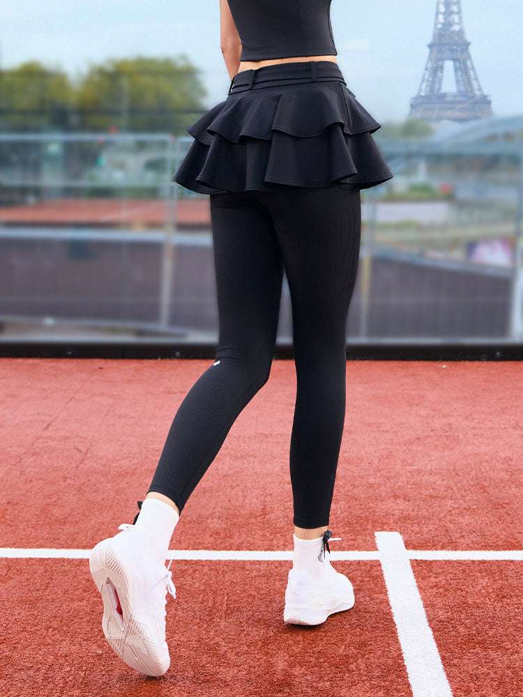 Black tennis leggings with a tiered ruffle skirt and high waist, stretchy fabric for comfort and active movement.