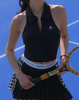 Black zip-front tennis tank with a collar and subtle logo, offering a chic look for on-court wear.