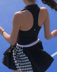 Black zip-front tennis tank with a collar and subtle logo, offering a chic look for on-court wear.
