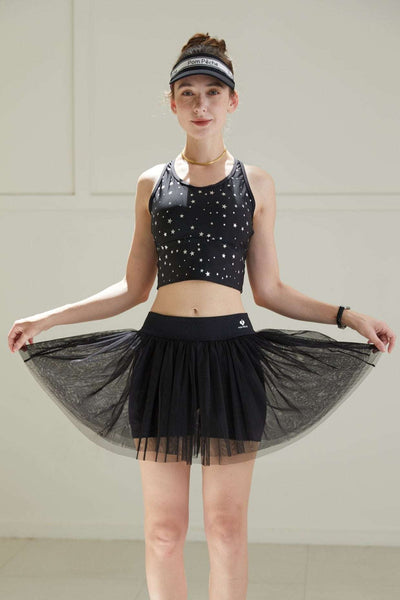 Front view of black tulle puff tennis skirt lifted to show mesh layers, emphasizing lightweight volume and high-waisted athletic silhouette.
