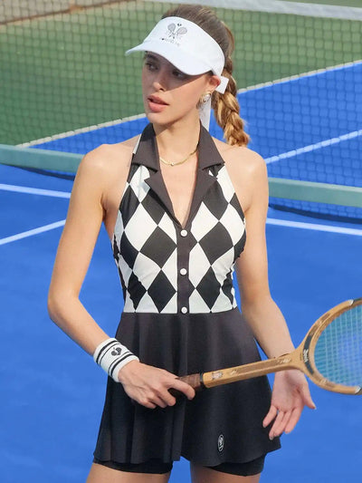 Black and white checkered tennis dress with a V-neck, flared skirt, and sleeveless design, styled on a tennis court.