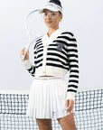 Model playin tennis wearing Pom Peche cardigan. 