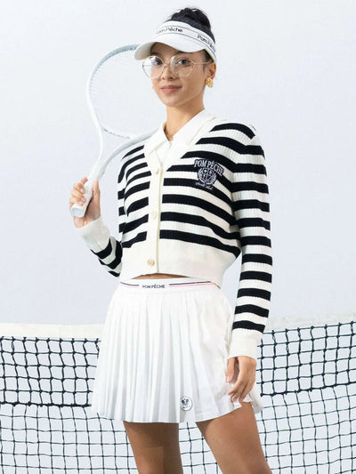 Model playin tennis wearing Pom Peche cardigan. 