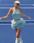 Tennis player in a light blue outfit on a tennis court