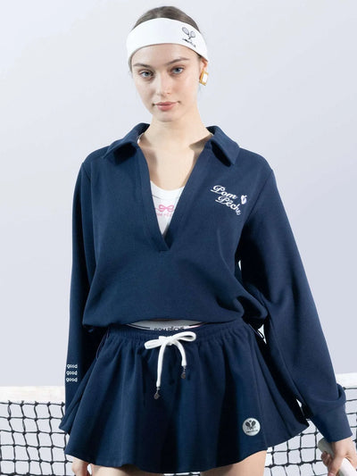 Woman wearing a navy blue sports outfit with a white headband on a light gray background