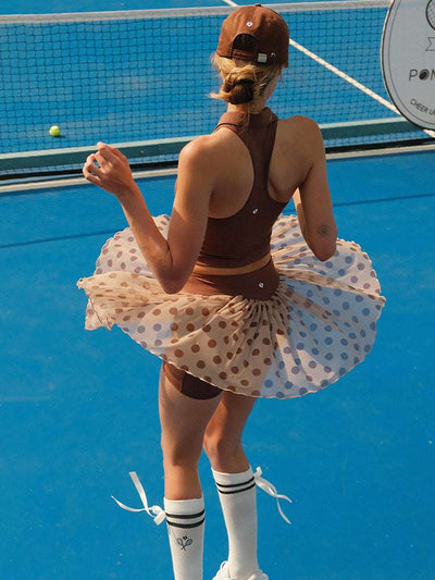 Brown zip-front tennis tank with a collar and subtle logo, offering a chic look for on-court wear.