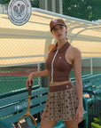 Brown zip-front tennis tank with a collar and subtle logo, offering a chic look for on-court wear.