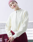 Cream fleece zip-up jacket with a soft texture and subtle logo detail, offering a polished yet cozy look.