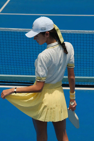 Woman in tennis attire on a blue court