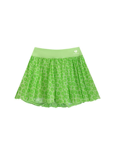 A product shot of a green leopard print mesh tennis skirt featuring airy pleated mesh and a wide waistband for secure movement.