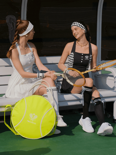 Green round tennis bag with white trim and handles, featuring Pom Pêche logo.