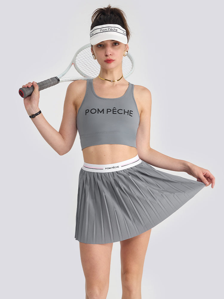 A women’s grey pleated tennis skirt designed for lightweight movement and court performance, styled with a sporty elastic waistband.