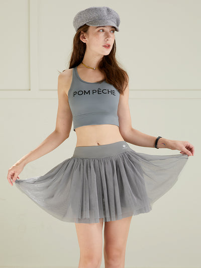 Grey puff tulle tennis skirt paired with matching sports top, highlighting lightweight mesh layers and high-waisted tennis skirt design.